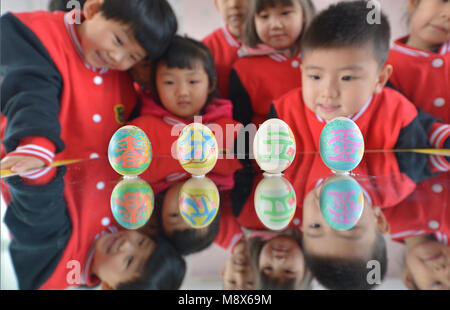 Handan. 21 Mär, 2018. Kinder spielen ein Spiel Eier am Ende zu stehen in einem Kindergarten in Handan, nördlich der chinesischen Provinz Hebei, März 21, 2018, auch den Tag der 'Chunfen'. Chunfen, was wörtlich bedeutet Frühlingspunkt oder Tagundnachtgleiche, fällt auf den Tag, wenn die Sonne genau auf die himmlischen Breitengrad von Null Grad. Credit: Dai Guoxiang/Xinhua/Alamy leben Nachrichten Stockfoto