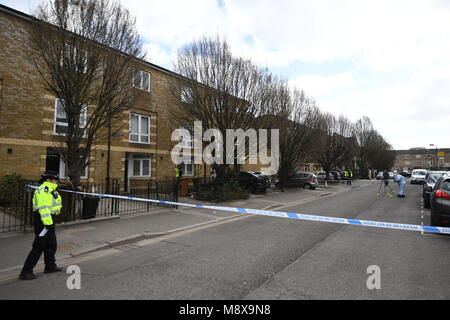 Eine forensische Officer (rechts) Fotos Patronen in Montgomery Street, Clapton, East London, und ein Polizist steht an der Tür einer Immobilie mit einem zerbrochenen Fenster, da die Polizei watchdog eine Untersuchung eingeleitet hat, nachdem ein Mensch, der einen Polizisten am Montag Nacht erschossen wurde. Scotland Yard sagte, daß es den Vorfall der unabhängiges Amt für Verhalten der Polizei (IOPC), deren Forscher an der Szene sind. Stockfoto