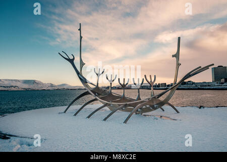 Sun Voyager Monument, Wahrzeichen von Reykjavik mit Blick auf das Meer und die Berge im Hintergrund, Island während des Sonnenuntergangs. Stockfoto