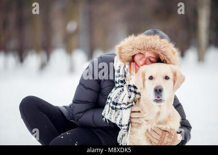 Foto von Frau in Schwarz Jacke hocken neben Hund in Winter Park Stockfoto