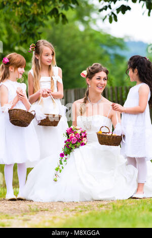 Braut im Brautkleid mit Brautjungfern Stockfoto