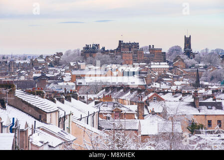 Snowy Blick über Lancaster, England, aus dem Osten mit Lancaster Castle und Klosterkirche in der Skyline Stockfoto