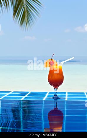 Glas orage Saft ist an der Kante der Pool aus glasierten Fliesen in Tropical Hotel gemacht, Malediven Stockfoto