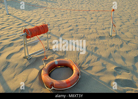 Sommer Meer, orange Rettungsring am Strand mit viel orange Seil Stockfoto