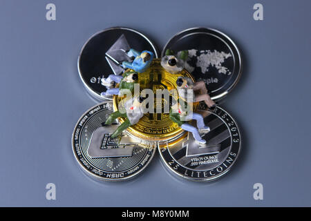 Münzen verschiedener crypto-Währungen mit statuette Leute sitzen auf Sie. Bitcoin, Bindestrich, Welligkeit, des Astraleums, litecoin Stockfoto