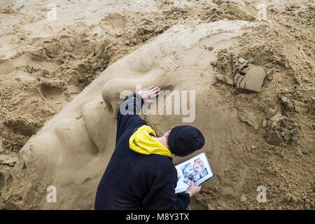 Ein Bildhauer eine Sand Skulptur am Ufer der Themse an der South Bank in London. Stockfoto