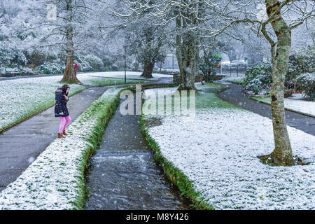 Ein junges Mädchen mit starker Schneefall in Trenance Gärten Newquay Cornwall. Stockfoto