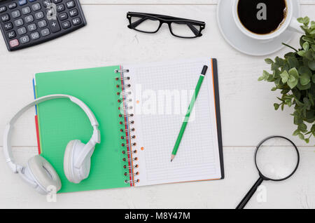 Büro Schreibtisch Tabellenlayout mit Kopfhörer, Tasse Kaffee und Zubehör. Flach Zusammensetzung auf weißem Holz- Hintergrund Stockfoto