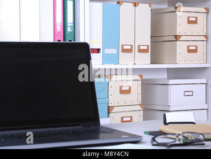 Close-up komfortables Arbeiten im Büro mit Laptops, Maus, Notebook, Gläser, Pen und anderen Geräten zur Festlegung auf Tabelle auf blur Möbel Hintergrund. Stockfoto