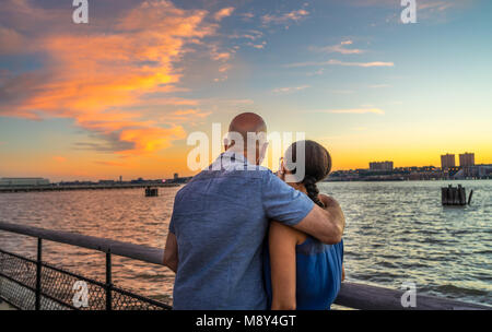 Paar beobachten, wunderschönen Sonnenuntergang im Riverside Park, Manhattan, NY Stockfoto