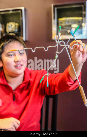 Ein Junge spielt Magnetische balancing Sticks in einem Spiel Zimmer Stockfoto