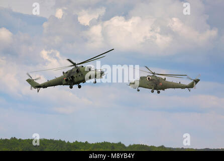 Fliegen zwei die polnische Luftwaffe Mil Mi-24D Hind-D während der International Air Show im 90. Jubiläumsjahr der polnischen Luftwaffe Akademie. Stockfoto