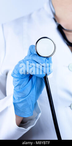 Arzt in blau Handschuhe, schwarz Stethoskop in der Hand auf weißem Hintergrund Stockfoto