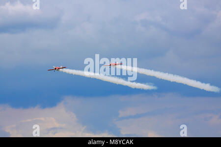 Paar a Zlin Z-50 LS Der Zelazny Aerobatic Team fliegen über stürmische Wolken bei International Air Show. Deblin, Polen, 20. Juni 2015. Stockfoto