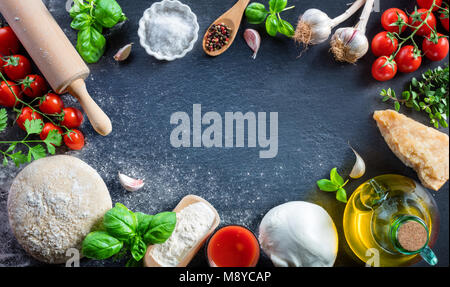 Pizza mit Zutaten auf Schwarz Tabelle - italienische Speisen Stockfoto