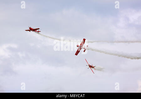 Die Extra 330LC und zwei einer Zlin Z-50 LS Der Zelazny Aerobatic Team fliegen über bewölkter Himmel während der International Air Show. Deblin, Polen. Stockfoto