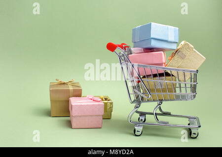 Bunte Geschenke, Supermarkt Warenkorb auf grünem Hintergrund mit freier Speicherplatz Stockfoto