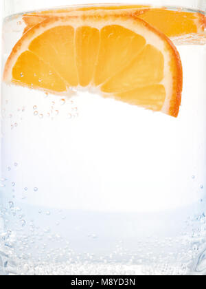Orange Scheiben in klare glitzernden Wasser. Nahaufnahme auf Weiß Stockfoto