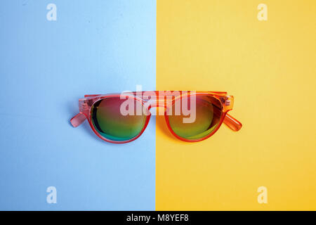 Flach Fashion Set: Sonnenbrille auf blauen und gelben Hintergrund. Mode Sommer kommt Konzept. Ansicht von oben. Trendy minimalistischen Stil mit bunten Papier Stockfoto