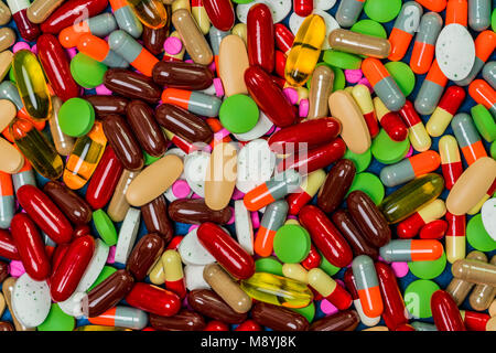 Stapel der bunten Pillen, Tabletten und Kapseln. Full Frame von Medizin, Vitamine und Nahrungsergänzungsmittel. Ansicht von oben viele Pillen Hintergrund. Arzneimittel, Vitamine, geschmeidig Stockfoto