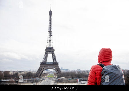 Junger Mann mit Rucksack auf den Eiffelturm in Paris, Frankreich Stockfoto