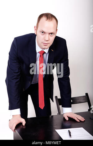 Ernsthafte Suche designer Mann stützte sich auf einen Tisch. Stockfoto