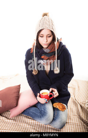 Frau genießt eine große Tasse frisch gebrühten heißen Tee, als sie auf einem Sofa im Wohnzimmer entspannt. Stockfoto