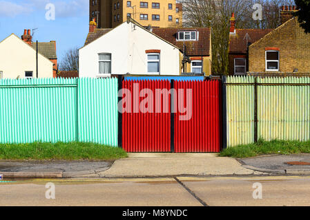 Farbenfrohe Wellpappe Zaun. Helle Farben. Farben. Sicken. Fechten. Rot. Blau. Türkis. Stockfoto