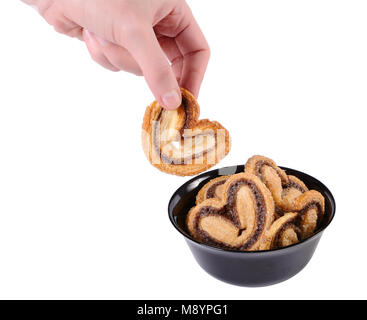 Hand, denn Cookies von einem schwarzen Schüssel isoliert auf weißem Stockfoto