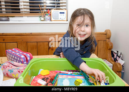 Junge Mädchen am Tisch Kommissionierung, Färbung Stifte Stockfoto