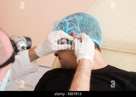 Mann in der Klinik geprüft von otolaryngologist. Arzt checkup Patienten Ohr. Stockfoto