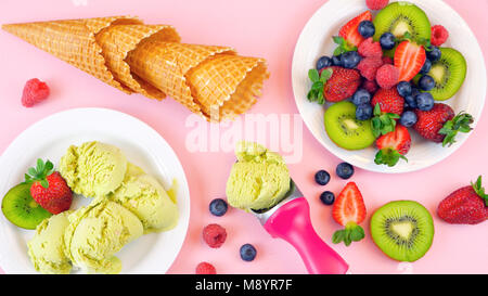 Mit Matcha grüner Tee Eis mit Waffeln und frische Früchte auf rosa Holz Tisch, Overhead flach. Stockfoto