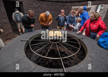 Lanzarote, Spanien - 12. Februar 2018: Touristische beobachten Cooking Demonstration in vulkanischen Nationalpark Timanfaya auf Lanzarote, Kanarische Inseln, Spanien. Stockfoto