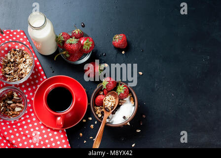 Gesundes Frühstück. Müsli mit Erdbeeren, Honig, Nüsse, Tasse starken Kaffee, Obst. Konzept einer gesunden Ernährung. Ansicht von oben, kopieren Raum Stockfoto