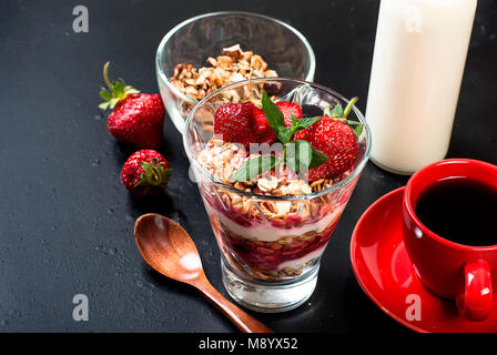 Gesundes Frühstück. Müsli mit Erdbeeren, Honig, Nüsse, Tasse starken Kaffee, Obst. Konzept einer gesunden Ernährung. Ansicht von oben, kopieren Raum Stockfoto