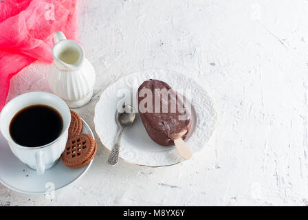 Frühstück leckeres Eis in Milchschokolade und eine Tasse starken Kaffee Stockfoto