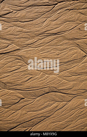 Sand Textur mit abstrakten Formen von Wasser bei Ebbe Stockfoto