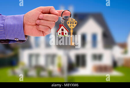 Schlüssel in der Hand von Real estate agent als Angebot für Ihr neues Zuhause Stockfoto