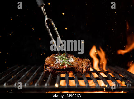 Fiery Grill Gitter mit Stück Rindfleisch Steak. Freier Platz für Text Stockfoto