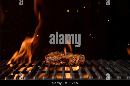 Fiery Grill Gitter mit Stück Rindfleisch Steak. Freier Platz für Text Stockfoto