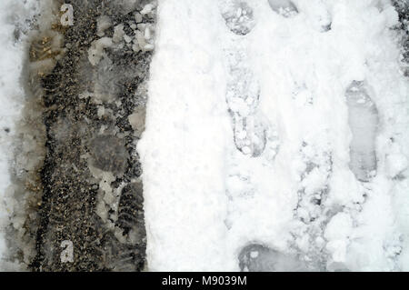 Fußabdrücke auf die Stadt Strasse mit Schnee bedeckt, Stockfoto