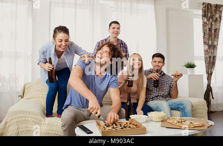 Eine Gruppe von Freunden essen Pizza beim Sitzen auf der Couch. Stockfoto