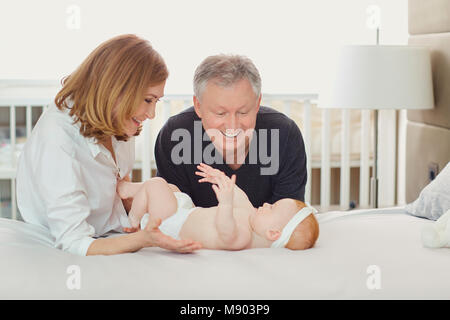 Großeltern und das Baby Spielen auf dem Bett. Stockfoto