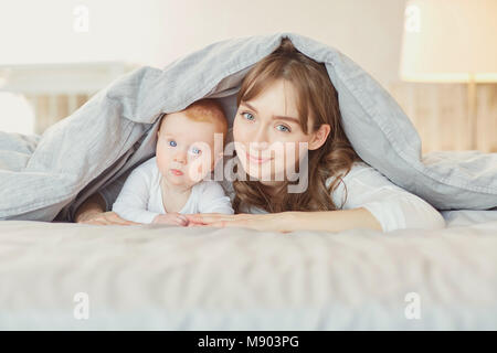 Portrait Mutter spielt mit den Kindern auf dem Bett. Stockfoto