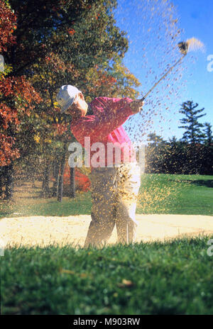 Ein Golfspieler strahlen seinen Weg aus einem Sandfang, USA Stockfoto