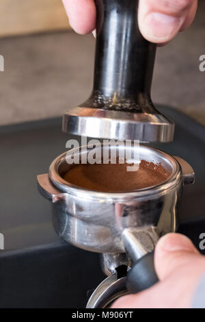 Barista Inverkehrbringen Stampfer über frische gestopft portafilter Kaffee, Cappuccino oder Espresso zu machen. Stockfoto