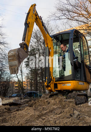 Sosnowy Bor, Russland - April 7, 2016: Mini Bagger graben unter der Stadt Kommunikation Stockfoto