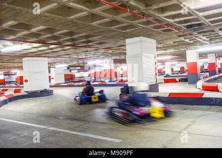 Zwei Menschen laufen auf Indoor Kartbahn in Tiefgarage entfernt Stockfoto