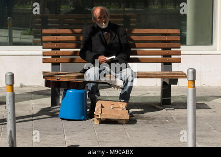 Gaukler mit blauen Eimer auf der Bank in der Altstadt von Limassol, Zypern, Mittelmeer Stockfoto