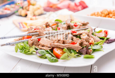 Im asiatischen Stil frischer Salat mit gegrilltem Rindfleisch, Lämmer, Salat, Tomaten und Sesam Stockfoto